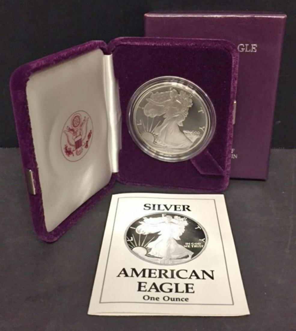 1990 Silver American Proof Eagle with Box & COA: 1990 Silver American Proof Eagle with Box & COA. This one ounce .999 fine iconic silver coin has deep mirrored fields and frosty cameo devices. Comes with its purple box of issue and COA.