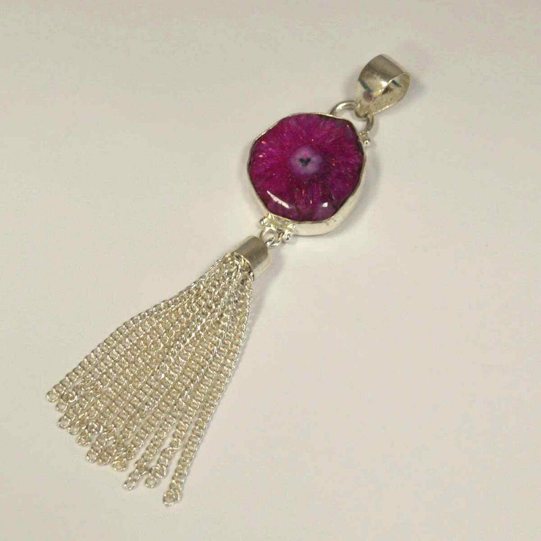 silver plated pink solar quartz pendant: Ladies silver plated pink solar quartz pendant featuring a bezel set slice of solar quartz and finished with tassel detail. Length 4". Weight 16.0 grams. IS-100