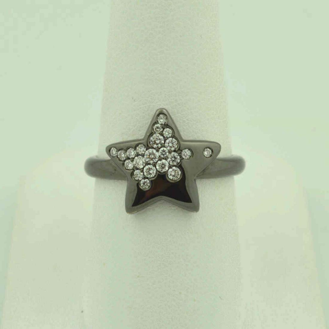 18kt diamond star fashion ring: 18kt black rhodium finish diamond star fashion ring featuring flush set round brilliant cut diamond weighing approx. 0.26ct. mounted on a star design. Finger size 7 1/4. Weight 6.3 grams. ZRDW22611-00