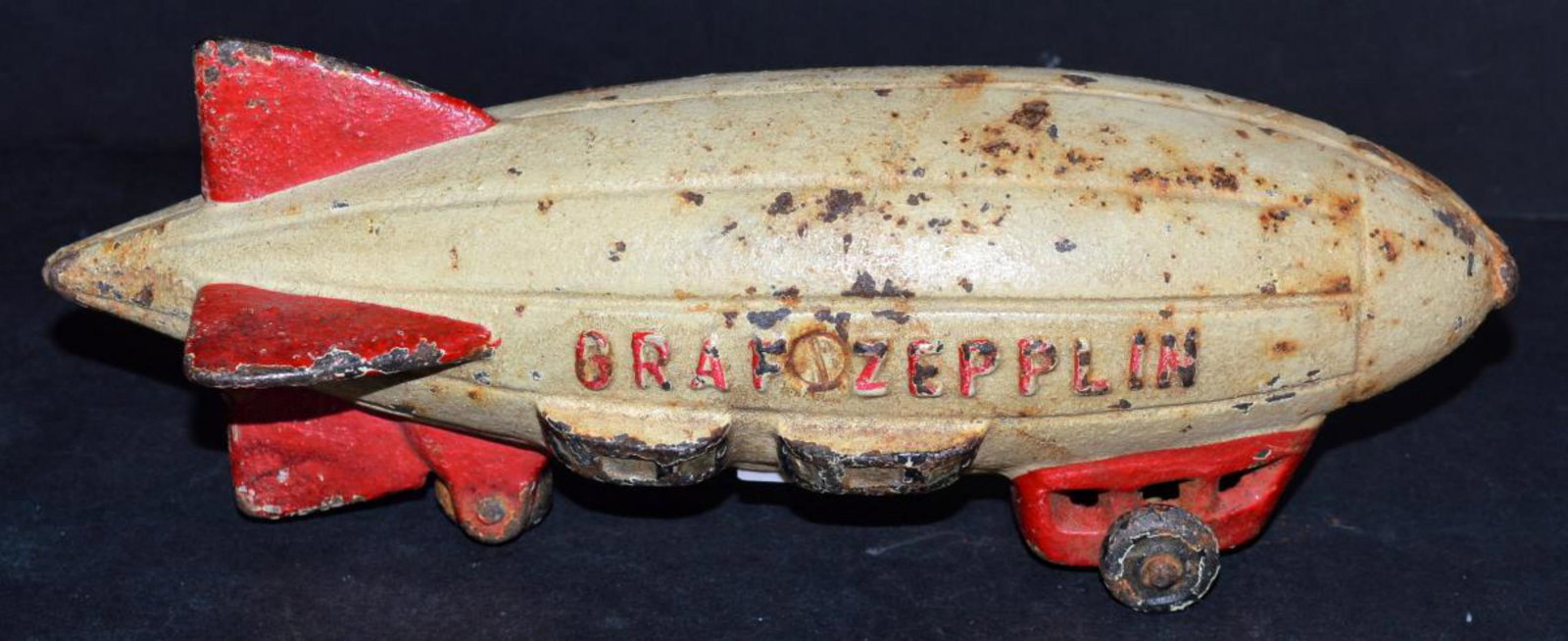 Graf Zepplin Cast Iron Toy: Graf Zepplin Cast Iron Toy White with Red Trim. 8.25" long 2.75" tall. All three wheels roll freely. No makers marks.