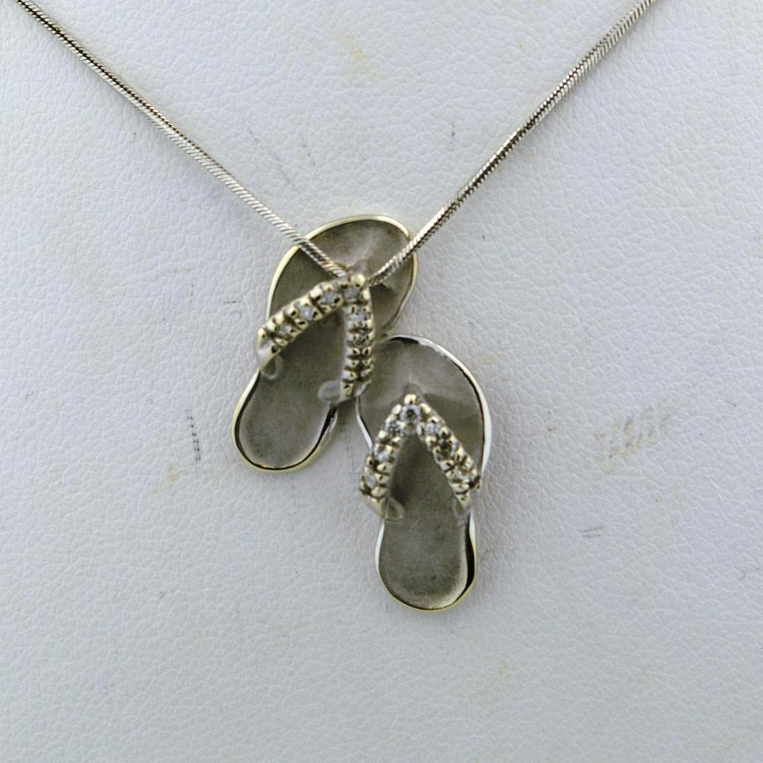 14kt white gold diamond sandals pendant: Ladies 14kt white gold diamond sandals pendant featuring a pair of white gold sandals accented with prong set round diamonds weighing approx. 0.07ct.. Hanging from an 18" chain. Weight 5.7 grams.