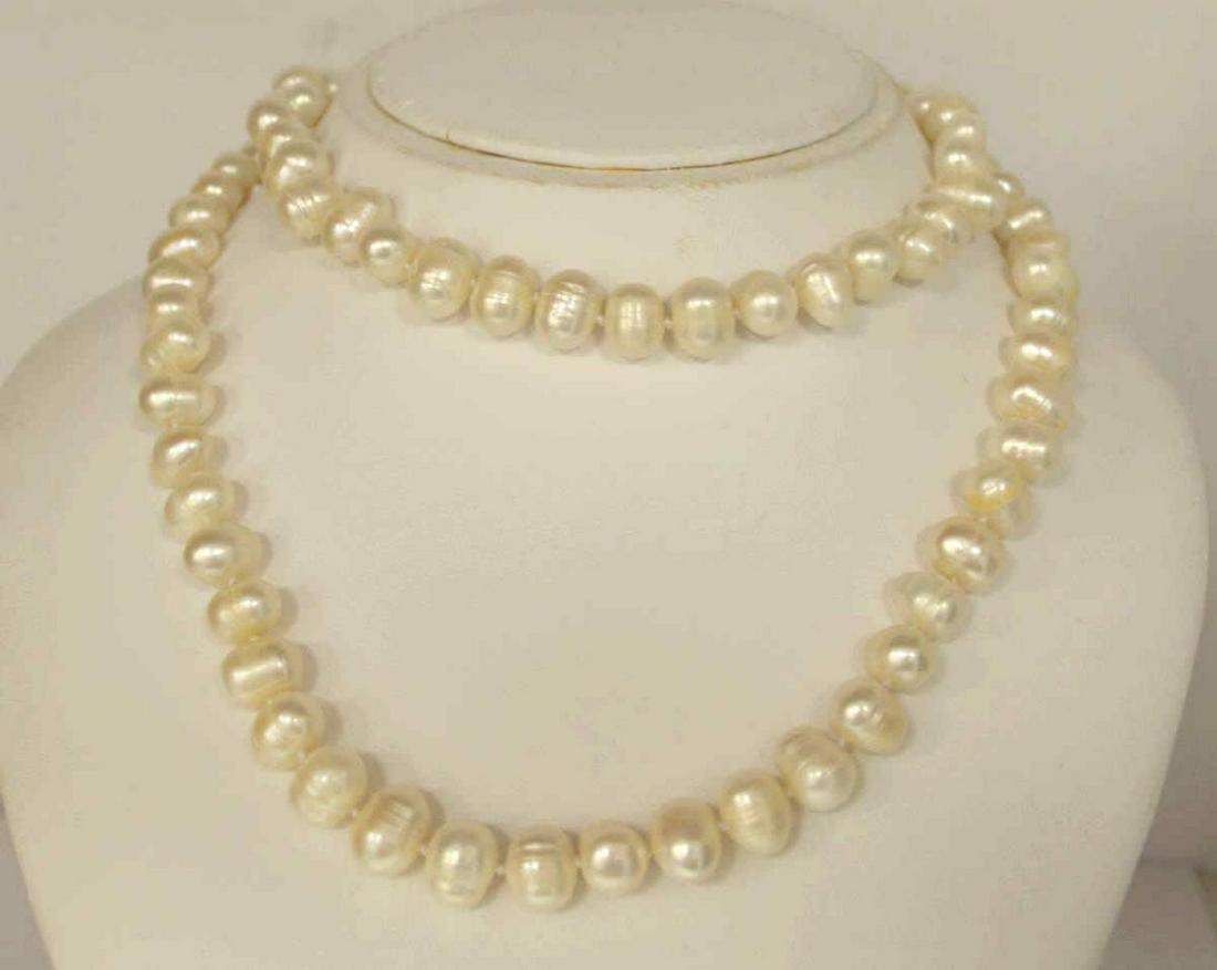 32" strand of fresh water pearls: Ladies 32" strand of fresh water pearls featuring single knotted creamy white freshwater pearls measuring 8-10mm. Finished with a gold toned lobster clasp.