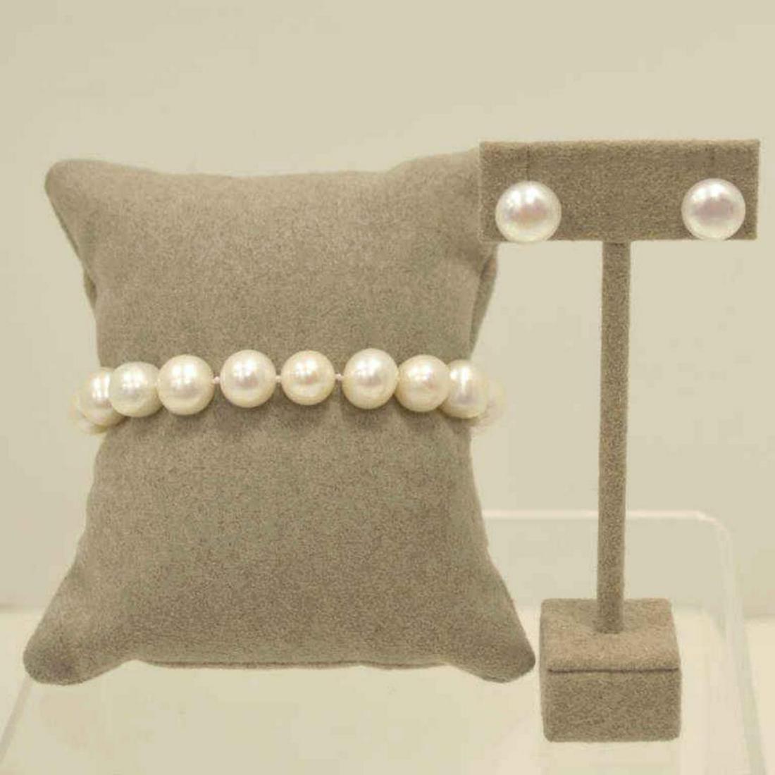 Freshwater pearl bracelet and earrings: Ladies 7.5" fresh water pearl bracelet featuring 10-11mm baroque pearls in a creamy white color. Single knotted with gold toned lobster clasp. Also included matching pearl stud earrings.