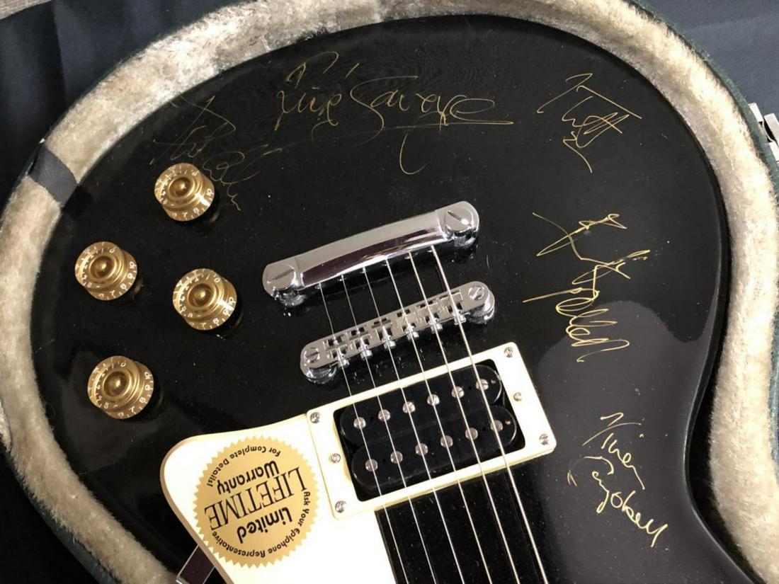 Def Leppard Band Signed Gibson Epiphone Guitar: Def Leppard Band Signed Gibson Epiphone Guitar with Hard Case. Autographed by Joe Elliot, Rick Allen, Rick Savage, Phil Collen, and Vivian Campbell. Untested. Sold "as is". Provenance: This is one of 
