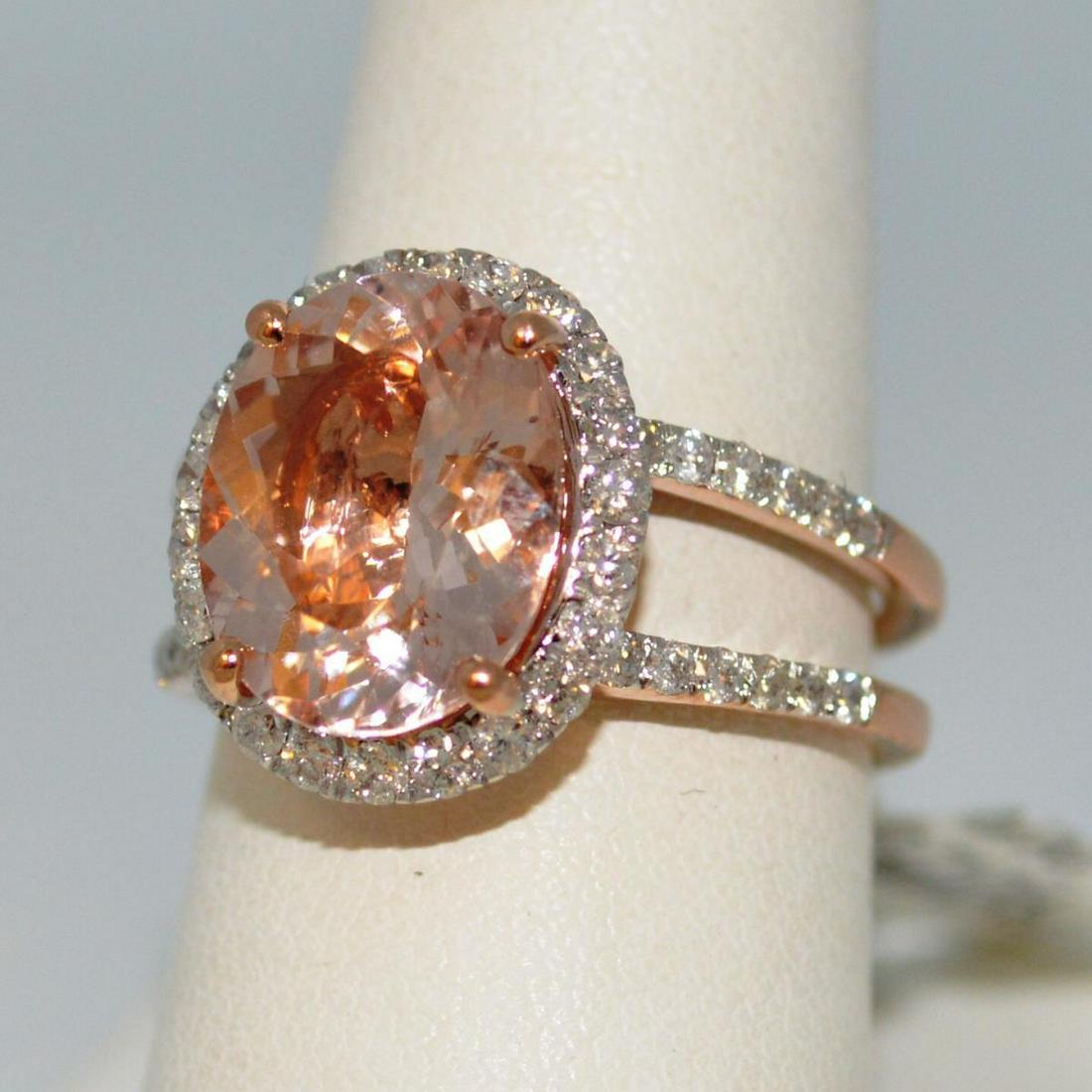 14kt rose gold morganite and diamond ring: Ladies 14kt rose gold morganite and diamond ring featuring a prong oval cut morganite weighing approx. 4.28ct.. Surrounded by a halo and split shank design of prong set round brilliant cut diamonds we