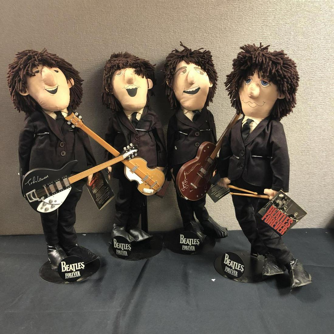 Set Of 4 Beatles Black Suits Dolls with Stands: Set Of 4 Beatles Dolls in Black Suits, with Stands. 4 dolls in set. Beatles Forever. 3 Dolls have guitars with them. 1 Doll has the drumsticks in his hand. Stands 9 1/2" tall. All are wearing black su