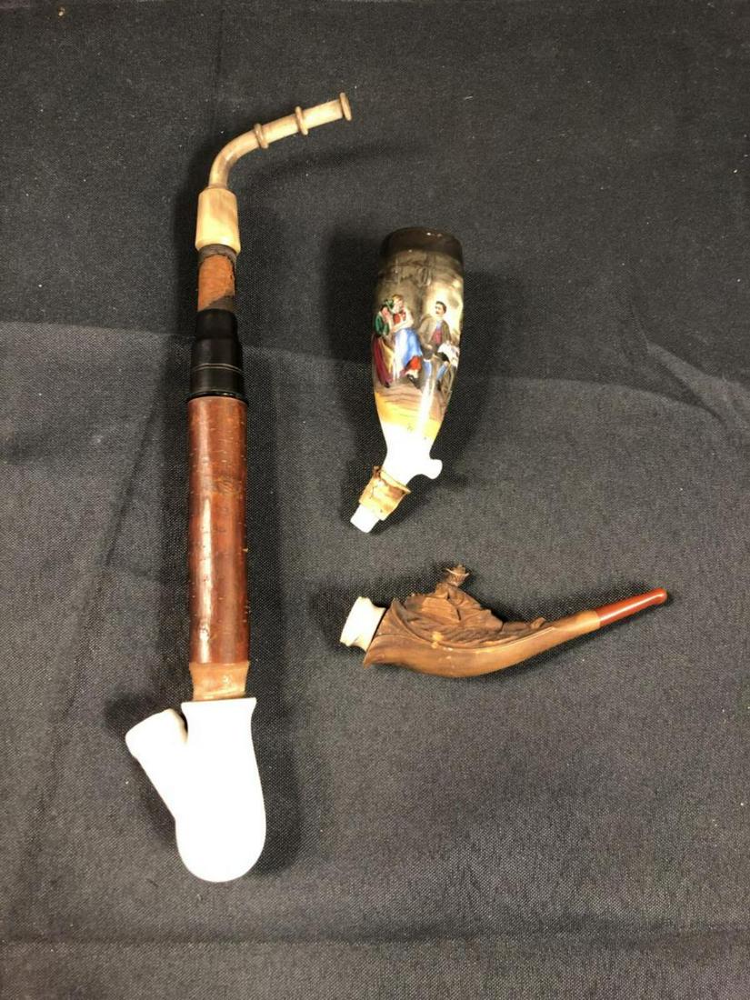 Pair Of Smoking Pipes: Pair Of Smoking Pipes. Two Smoking Pipes. A figural, carved pipe measuring 4 3/4"long. Porcelain & Wood Pipe with Enameled Tavern Scene Measuring 11 1/4" long.
