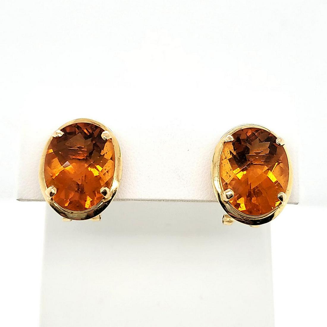 14kt yellow gold citrine earrings: Ladies 14kt yellow gold citrine earrings featuring prong set oval checkerboard cut citrine weighing approx. 16.60ct.. Mounted in an 14kt bezel and finished with omega backs. Gross weight 6.5 grams.