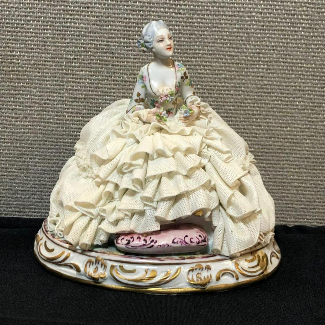 Capodimonte Luigi Fabris Figurine Lace Lady Chair: Capodimonte Luigi Fabris Porcelain Figurine Lady in Chair. Measures about 5.5" at its highest, and about 6" at its widest. Small portion of lace missing, and a repair made to base. Red hallmark on bot