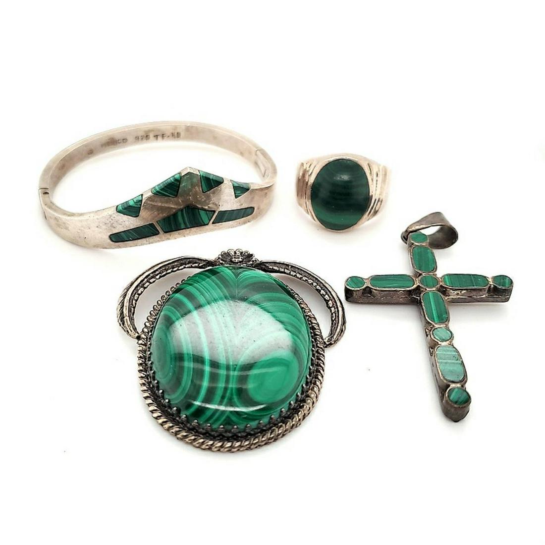 Lot of sterling silver malachite jewelry: Lot of sterling silver malachite jewelry including a large oval pendant measuring 2" long, malachite cross pendant measuring 2.5" long, ring with bezel set oval cut cabochon, finger size 10, and bangl