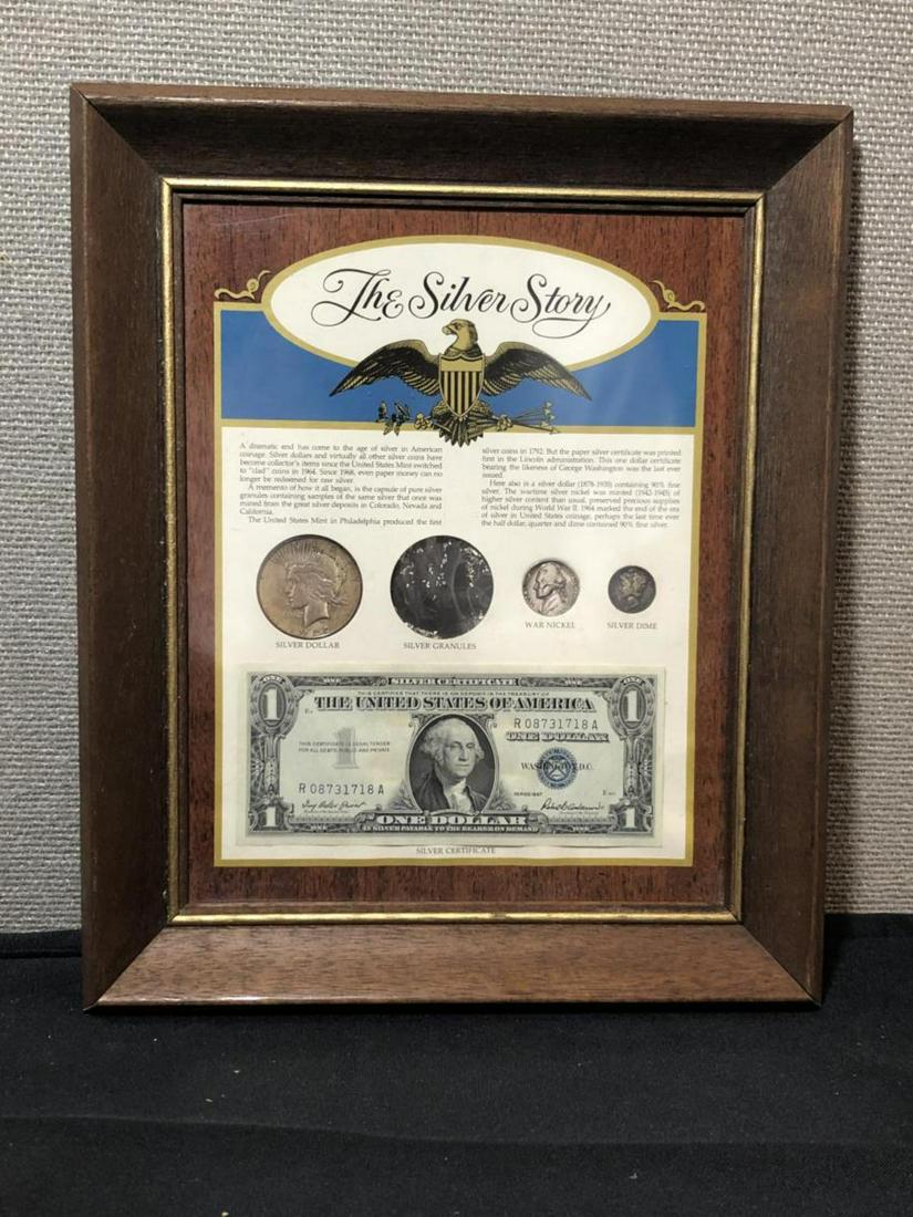 Framed "The Silver Story" w/ Peace $1: Framed "The Silver Story" w/ Peace $1, a pinch of silver granules, a silver wartime Jefferson Nickel, a silver Roosevelt Dime, and a 1957 Silver Certificate currency note, all housed in a wood frame u