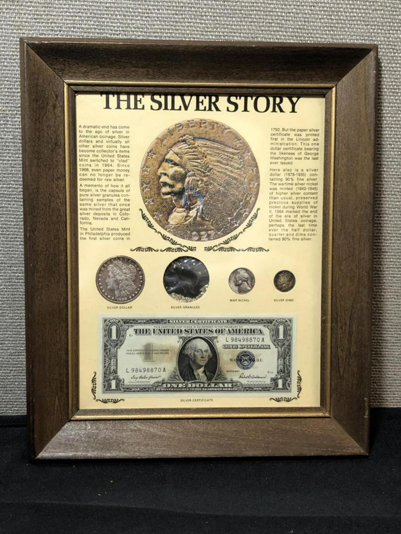 Framed "The Silver Story" w/ Morgan $1: Framed "The Silver Story" w/ Morgan $1, a pinch of silver granules, a silver wartime Jefferson Nickel, a silver Mercury Dime, and a 1957 Silver Certificate currency note, all housed in a wood frame un