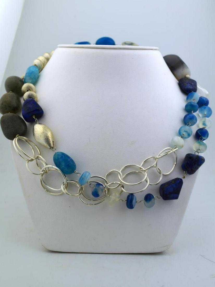 Blue onyx and lapis lazuli bead necklace: Ladies blue onyx and lapis lazuli bead necklace featuring various sizes and shapes of dyed blue onyx, lapis lazuli and other additional agate stones. Accented with silver color beads. Length 36". Ston