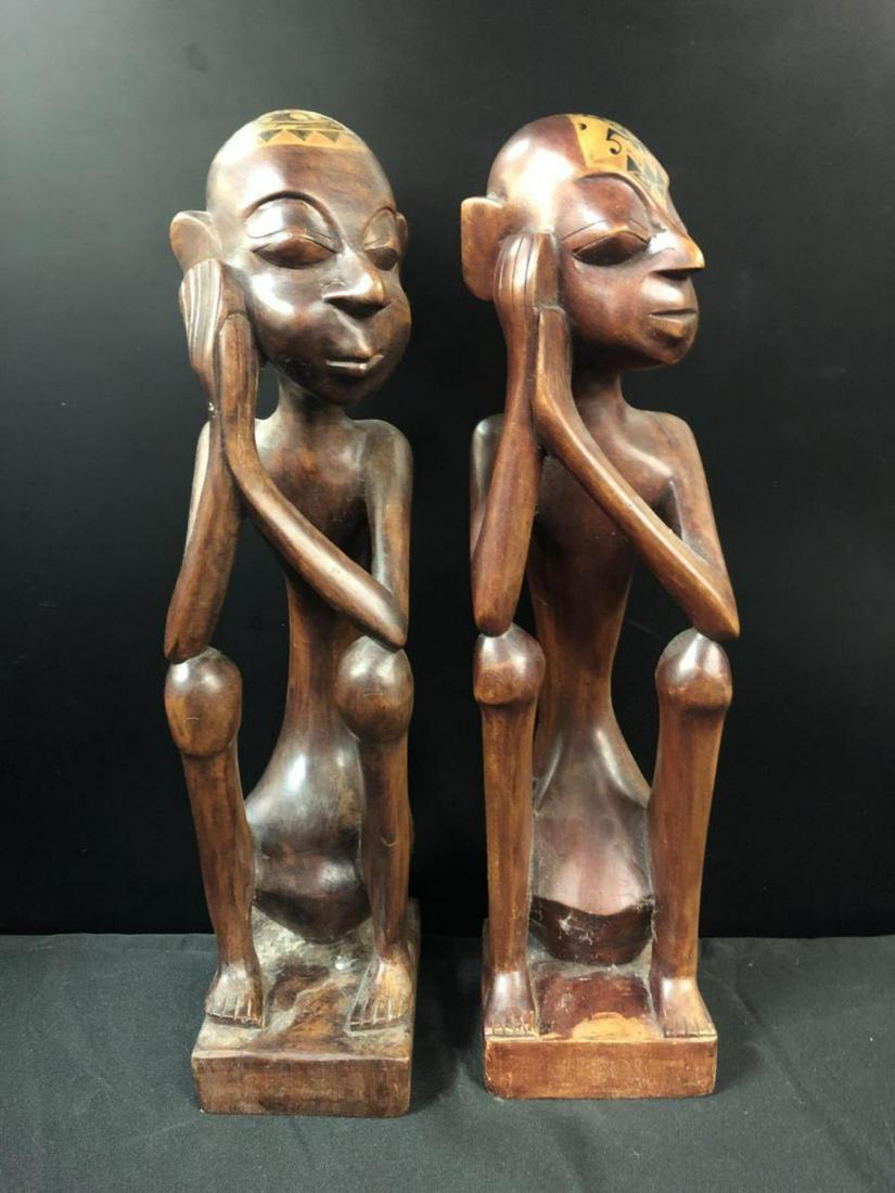 Pair Of Carved African Figurines: Pair Of Carved African Figurines. Mahogany hand carved. Figurines are on wood base. Stands 16" tall. tribal man squatting with hands clinched together. Kencana Gallery Oil Batik Art Silver & Pearl lab