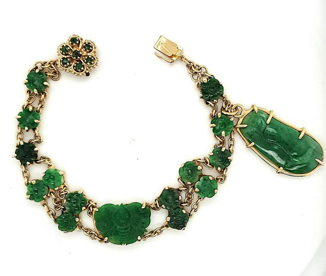 14kt yellow gold green jadeite bracelet: Ladies 14kt yellow gold green jadeite bracelet containing carved decorative links depicting flowers, a bee and prong and bezel set carved freeform drop charm. Accented with prong set round emeralds on