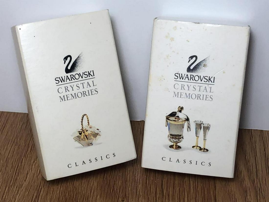 Swarovski Champagne & Floral Basket Memories Piece: Swarovski Champagne & Floral Basket Memories Pieces w/Boxes. Both are in original boxes. First one features a floral basket, the other is of 2 champagne glasses and ice bucket with gold colored draped