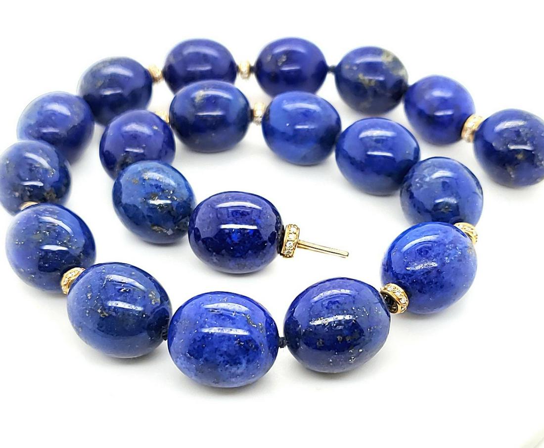18” strand of blue lapis lazuli beads: Ladies 18” strand of blue lapis lazuli beads measuring approx. 17mm. and accented with 14kt yellow gold separator beads containing prong set round brilliant cut diamonds, estimated total carat weigh