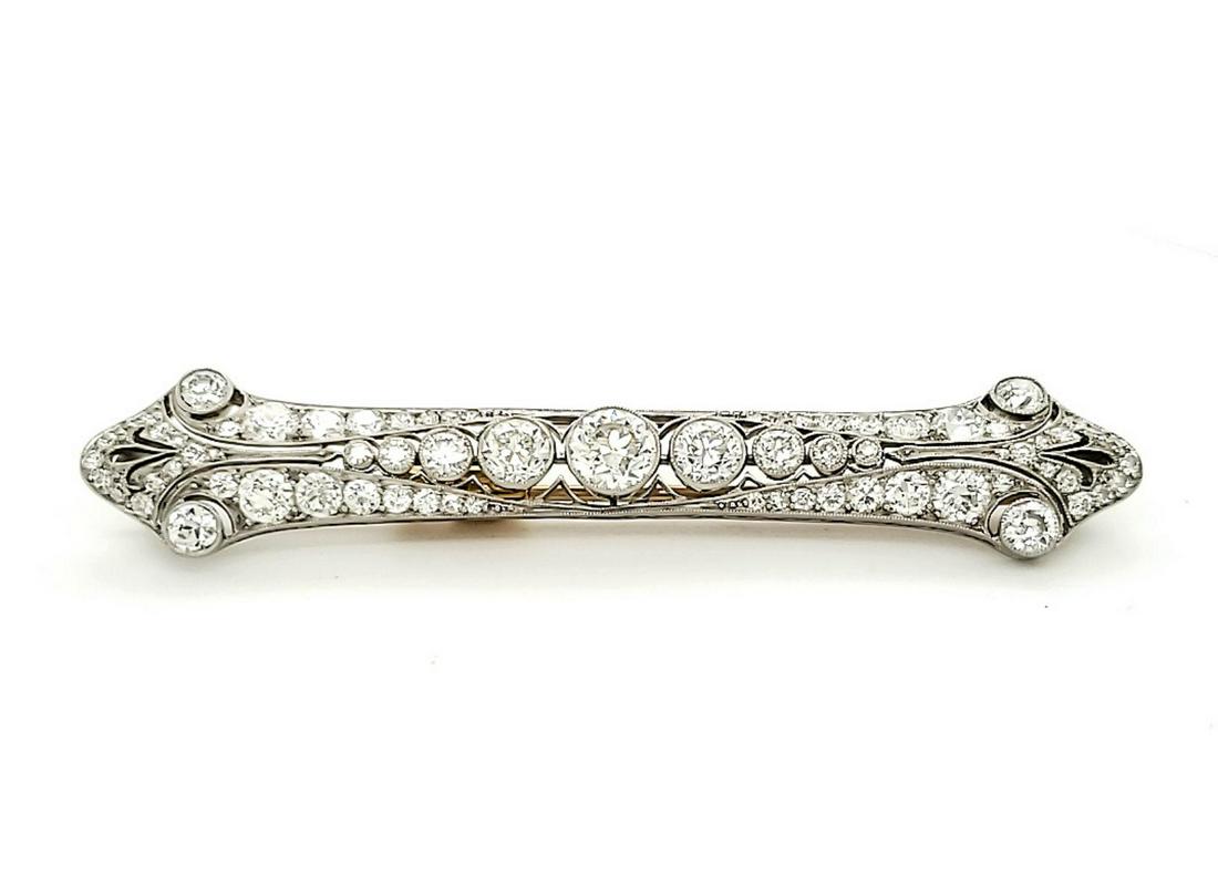 Tiffany & Co. platinum and diamond bar pin: Ladies platinum and diamond Art Deco style bar pin signed “Tiffany & Co.”. Containing in the center of the piece graduated bezel set round European cut diamonds. Scrolling type of design towards t