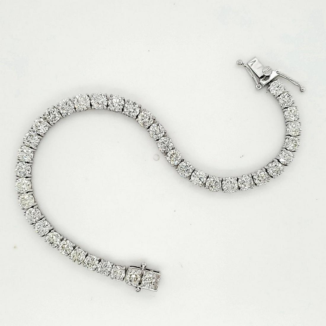 18kt white gold diamond tennis bracelet: Ladies 18kt white gold diamond tennis bracelet featuring prong set round brilliant cut diamonds weighing approx. 13.11ct., Clarity I1-I2, Color I-J. Length 7". Weight 15.5 grams. Comes with an AIGL ap