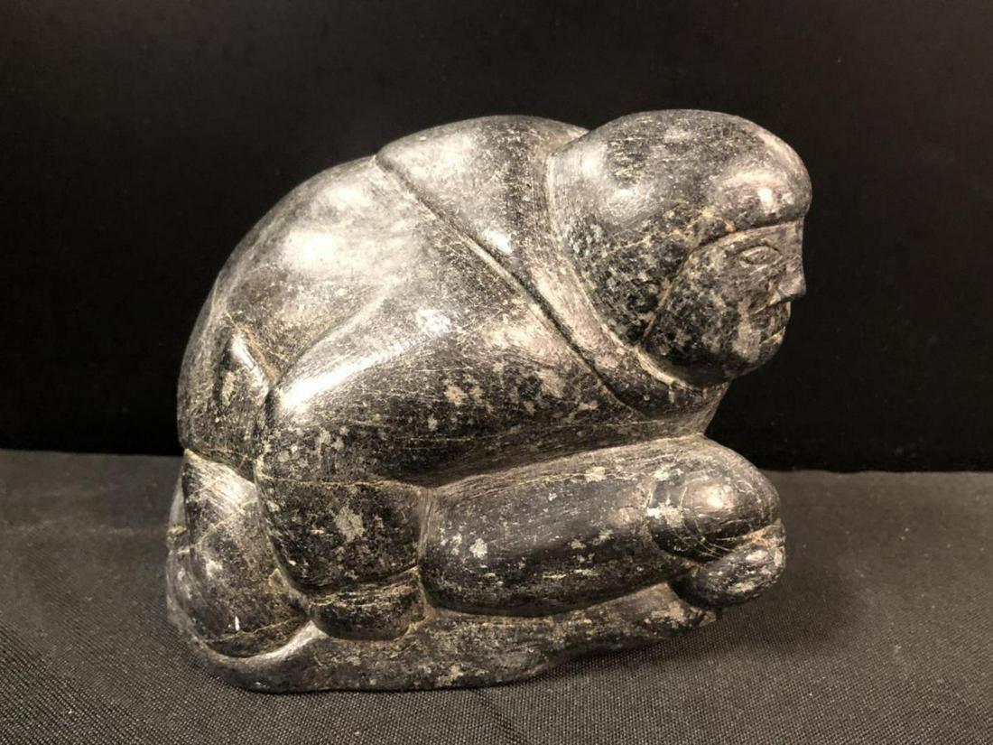 Soapstone Stone Eskimo Statue: Soapstone Stone Eskimo Statue. Stands 4 1/2" tall. Measures 5" across. Small booklet on the bottom of the Eskimo statue.