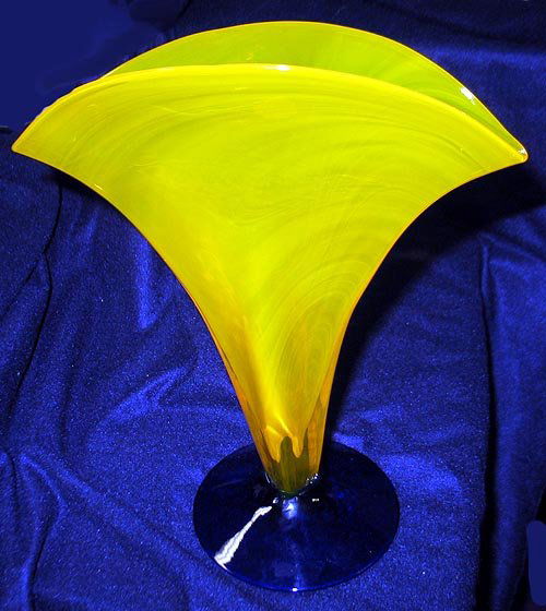 Blenko Glass vase: Blenko Glass handcrafted Vase made in the USA. Vase has a yellow fan shaped blown glass body attached to a cobalt blue foot. The vase stands 11 3/4" tall and fans out to 10" across the top. With origi