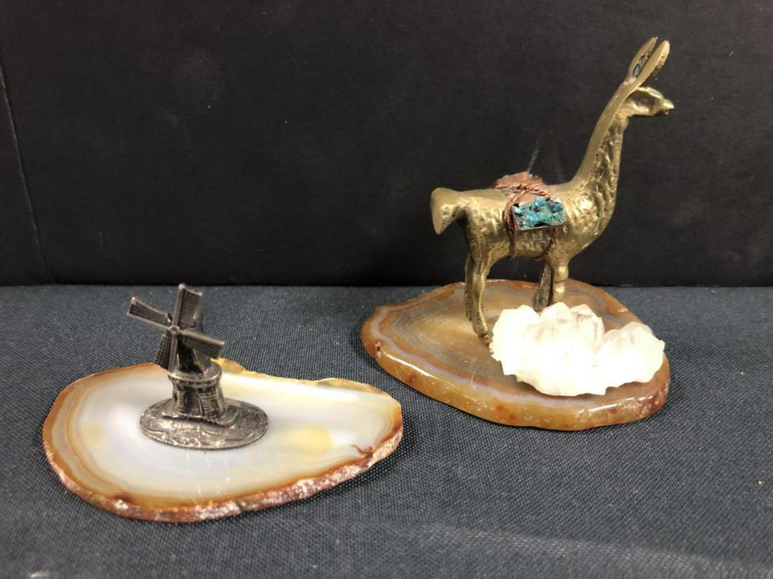 Agate Geode Slices with Brass Figurines: Agate Geode Slices with Brass Figurines. One features a brass Alpaca, with a white crystal formation as snow, and measures 3" in length, and 3" in height. The other piece feature a windmill, and measu