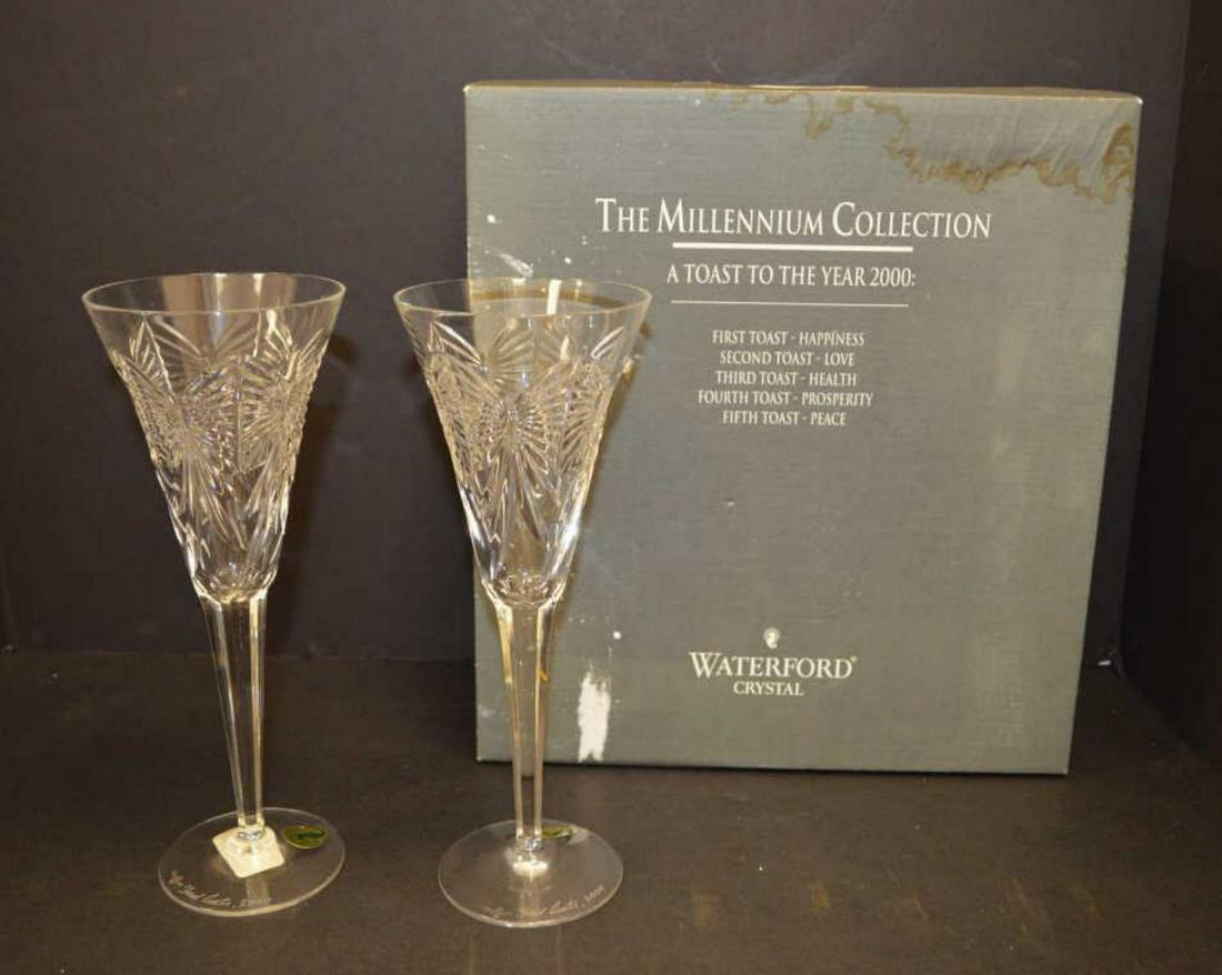 Signed Pair of Waterford Millennium Flutes: Pair if Waterford crystal Millennium Toasting Flutes in the Happiness pattern. In the original box. Both glasses are signed by Fred Curtis with the year 2000. Some damage to the box.