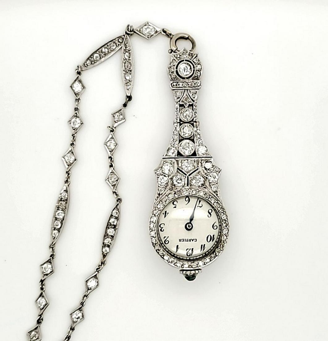Vintage Cartier platinum diamond pendant watch: Ladies platinum diamond pendant watch marked “Cartier” featuring a long pendulum case style accented with prong and bezel set round European and single cut diamonds. Hanging from a fancy link chai