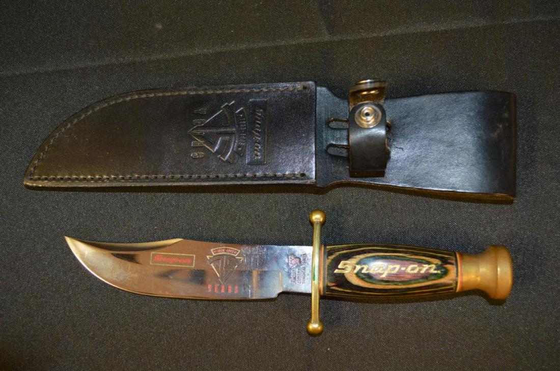 Snap-On Tools 75th Anniversary Buck Knife w Sheath: Snap-On Tools 75th Anniversary Buck Knife with Sheath. Laminated multi colored handle embossed in gold with "75 YEARS SNAP-ON 1920-1995". Brass pommel & knuckle guard. Black leather sheath is also emb