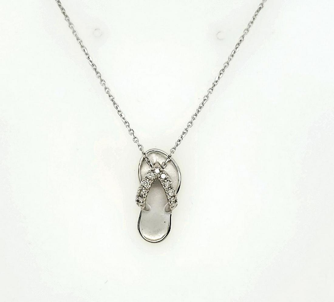 14kt white gold diamond sandal pendant: Ladies 14kt white gold diamond sandal pendant featuring prong set round diamonds weighing approx. 0.09ct.. Hanging from a 16" chain. Weight 3.4 grams.
