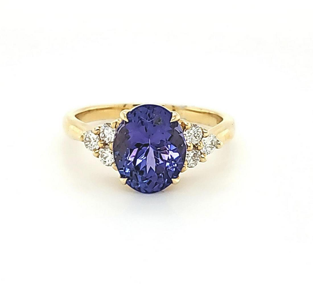 14kt yellow gold tanzanite and diamond ring: Ladies 14kt yellow gold tanzanite and diamond ring featuring a prong set oval cut tanzanite weighing approx. 3.04ct.. Accented with prong set round brilliant cut diamonds weighing approx. 0.31ct. Fing