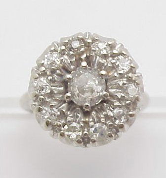 Vintage Diamond Cocktail Ring 14kt: 14K white gold lady's diamond circular design vintage cocktail ring, 6.15 grs. with one center, old mine cut diamond, chips on girdle, approx. .58 cts, J, I1, & 2 round single & 8 old mine cut accent