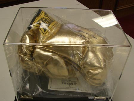 Muhammad Ali Signed Boxing Gloves: Muhammad Ali Signed Gold Boxing Gloves in plexigas display case, issued by Stacks of Plaques, No. 28 of 500 with COA.