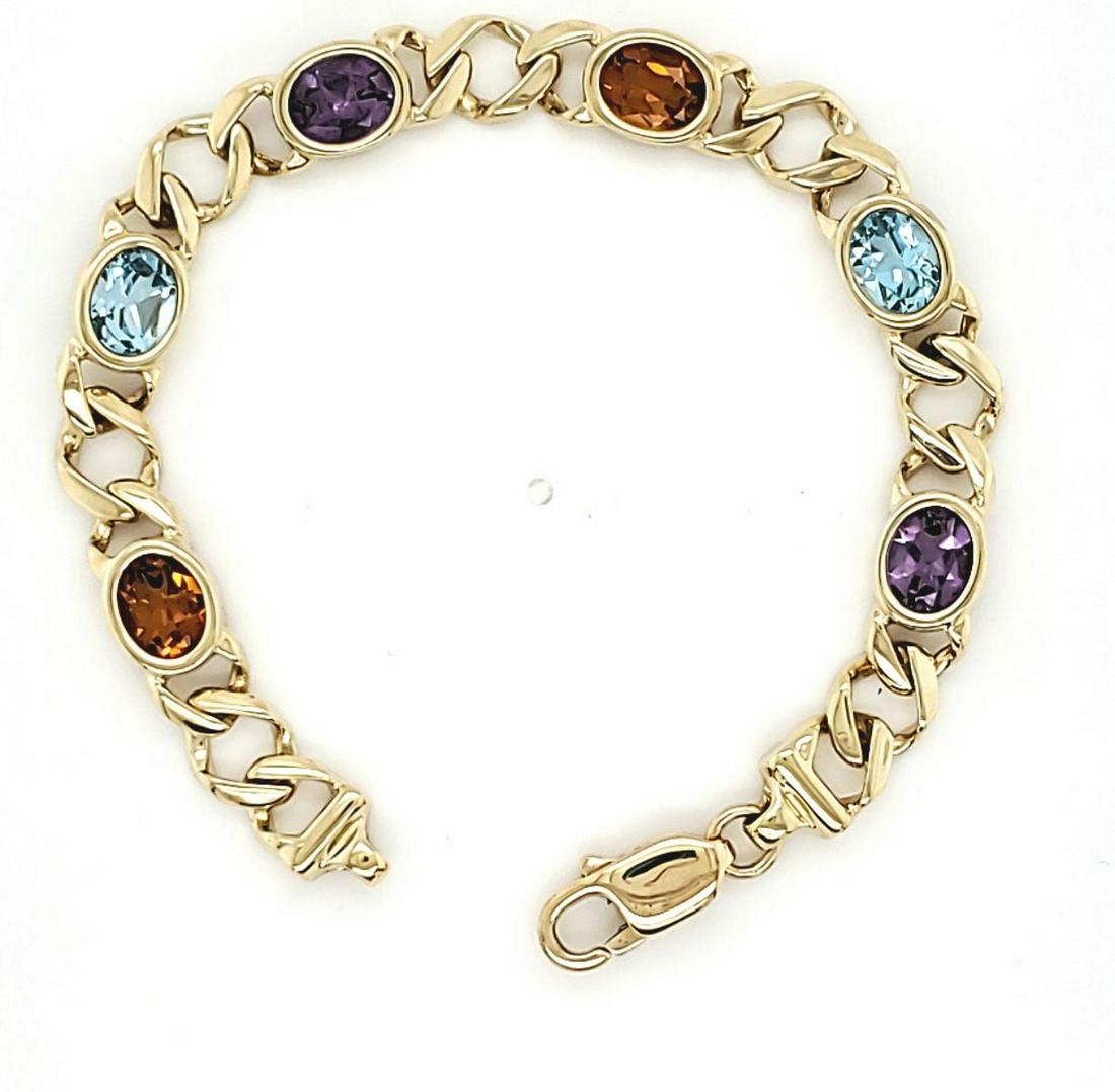 14kt yellow gold multi-color stone bracelet: Ladies 14kt yellow gold multi-color stone bracelet featuring bezel set oval cut amethyst, blue topaz, and citrine stone measures 6.5 x 4.5mm. Separated by square fancy links. Measures 7mm wide and 7".