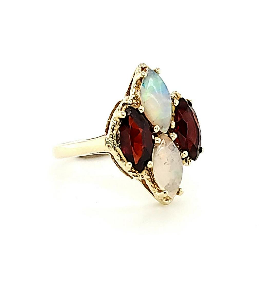 Garnet and Opal Ring: Lady's 14kt y/g ring with two marquise cut opals and two marquise garnets. Size 6 1/4. Weight 3.2gr.