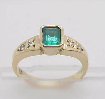 18ky emerald/diamond ring: Lady's 18kyg emerald and diamond ring weighing 4.2 grams. Ring contains one emerald cut Columbian emerald measuring 5X4mm and 4 round full cut diamonds .10ctw two on either side of center. Finger size