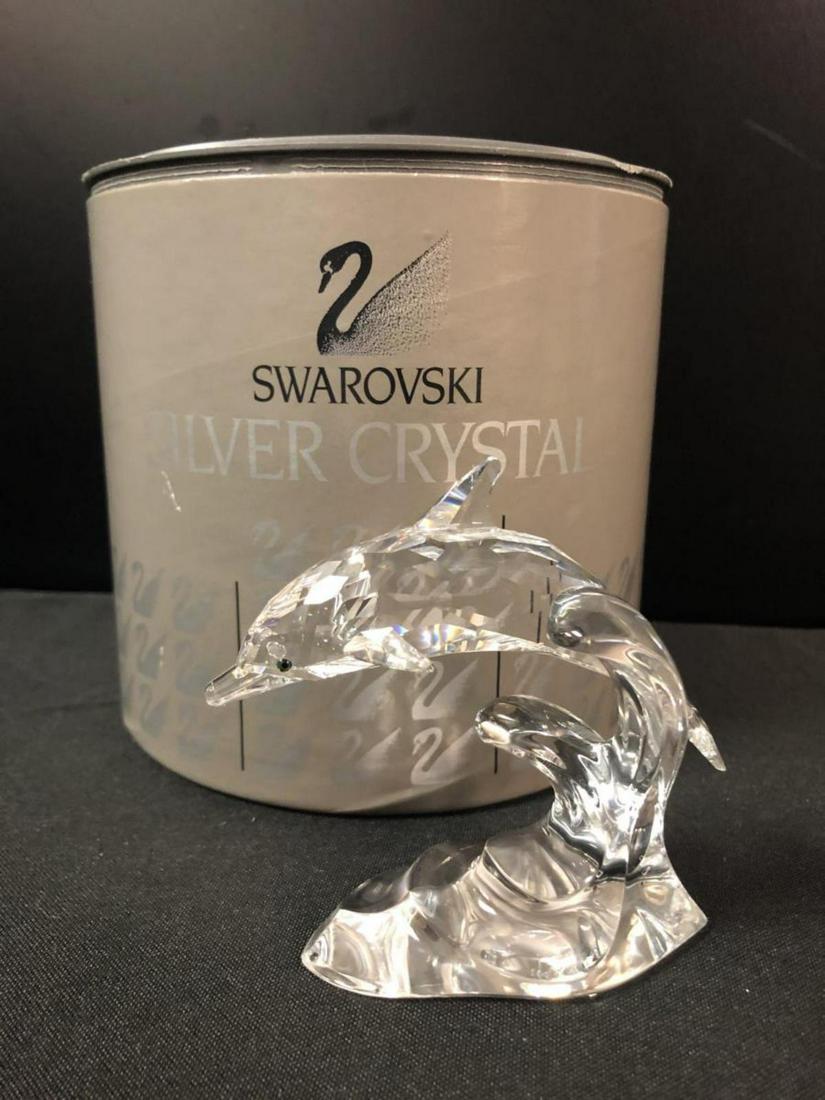 Swarovski Crystal Dolphin in Original Tube: Swarovski Crystal Leaping Dolphin in Original Tube. This great dolphin figurine is 3 3/4" long & 3 3/4" tall & is on a wave base. Green crystal eyes. It is acid etched from the Swarovski Co. on the un