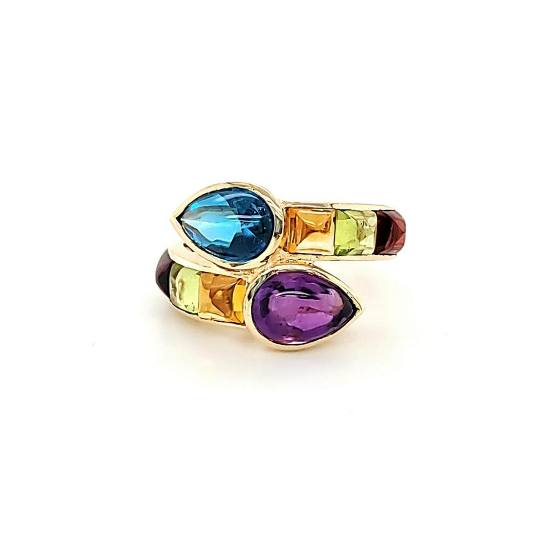 Lady's multi colored stone ring: Lady's 14kt yellow gold by-pass style ring featuring bezel set 9x6mm cabochon blue topaz and amethyst with square cabochon citrine, peridot and garnet on each side. weight 5gr. Size 9.25