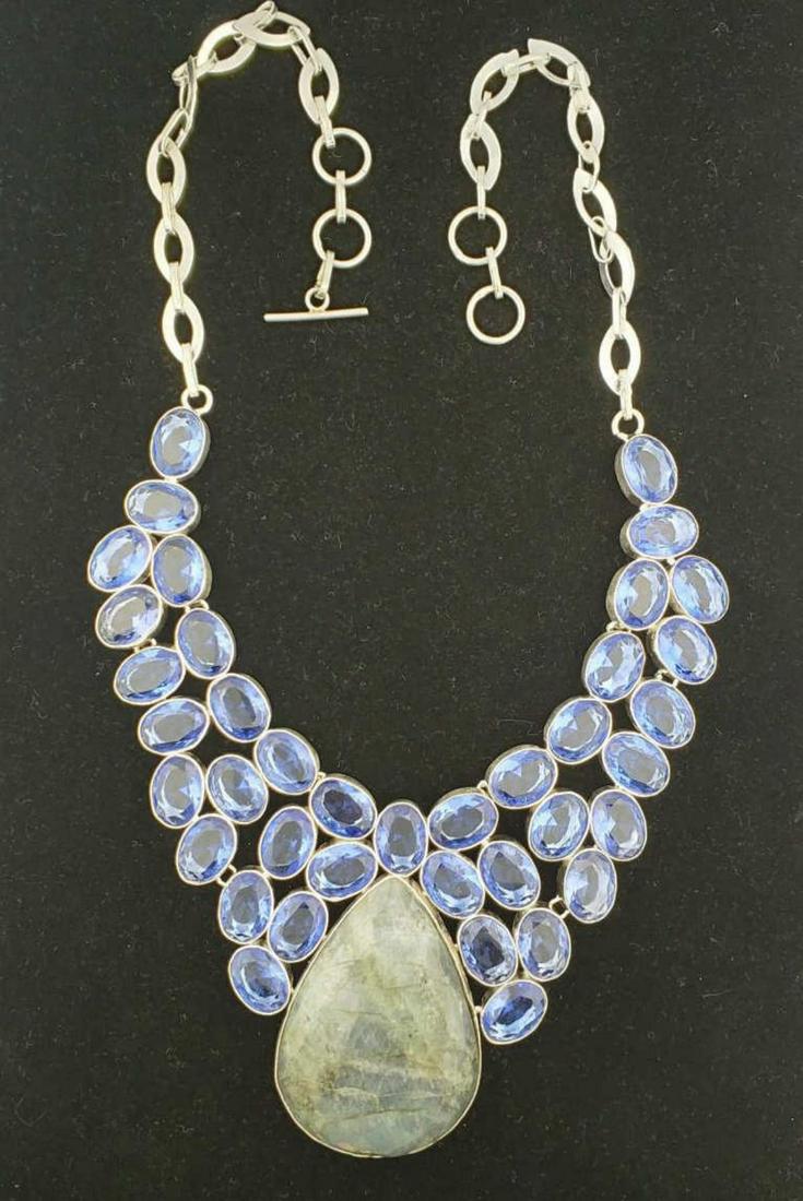 labradorite and lab created tanzanite necklace: Ladies silver plated labradorite and lab created tanzanite necklace featuring a pear shaped cabochon labradorite, accented with oval cut lab created tanzanite Total gem weight approx. 301.00ct. Length
