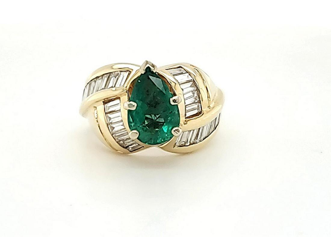 14kt yellow gold emerald and diamond ring: Ladies 14kt yellow gold emerald and diamond ring featuring a prong set pear shaped emerald weighing approx. 1.31ct..Accented with rows of channel set baguette cut diamonds weighing approx. 2.00ct., Cl
