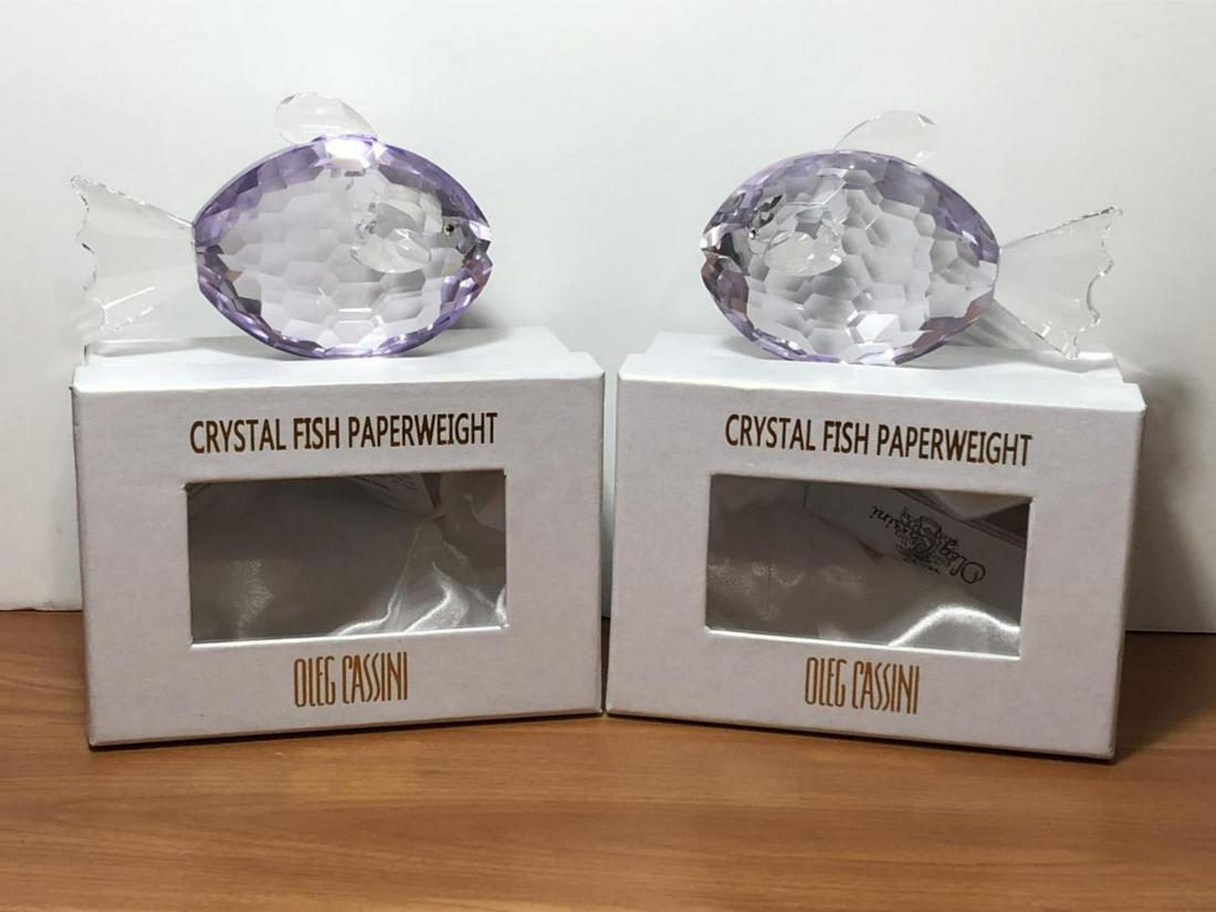 Pair Oleg Cassini Large Crystal Fish Paperweights: Pair of Oleg Cassini Large Crystal Fish Paperweights New In Box. Each fish is lavender in color, is 4.5” in length and sits 3” at its tallest. Each fish is etched Oleg Cassini on the bottom and co
