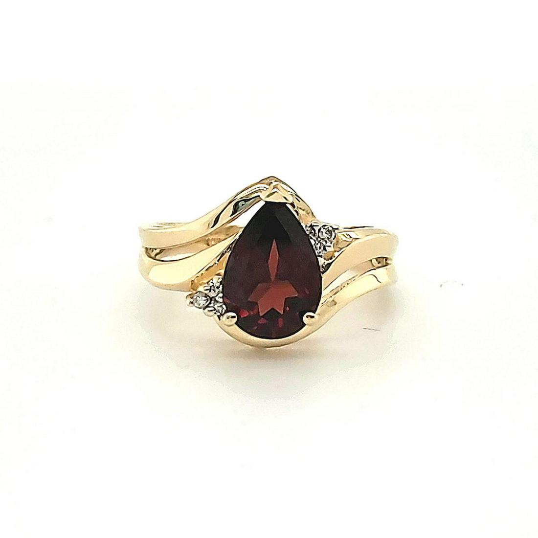 14kt yellow gold garnet and diamond ring: Ladies 14kt yellow gold garnet and diamond ring featuring a prong set pear shaped garnet weighing approx. 2.06ct.. Accented with prong set round diamonds weighing approx. 0.06ct. Finger size 7. Weight