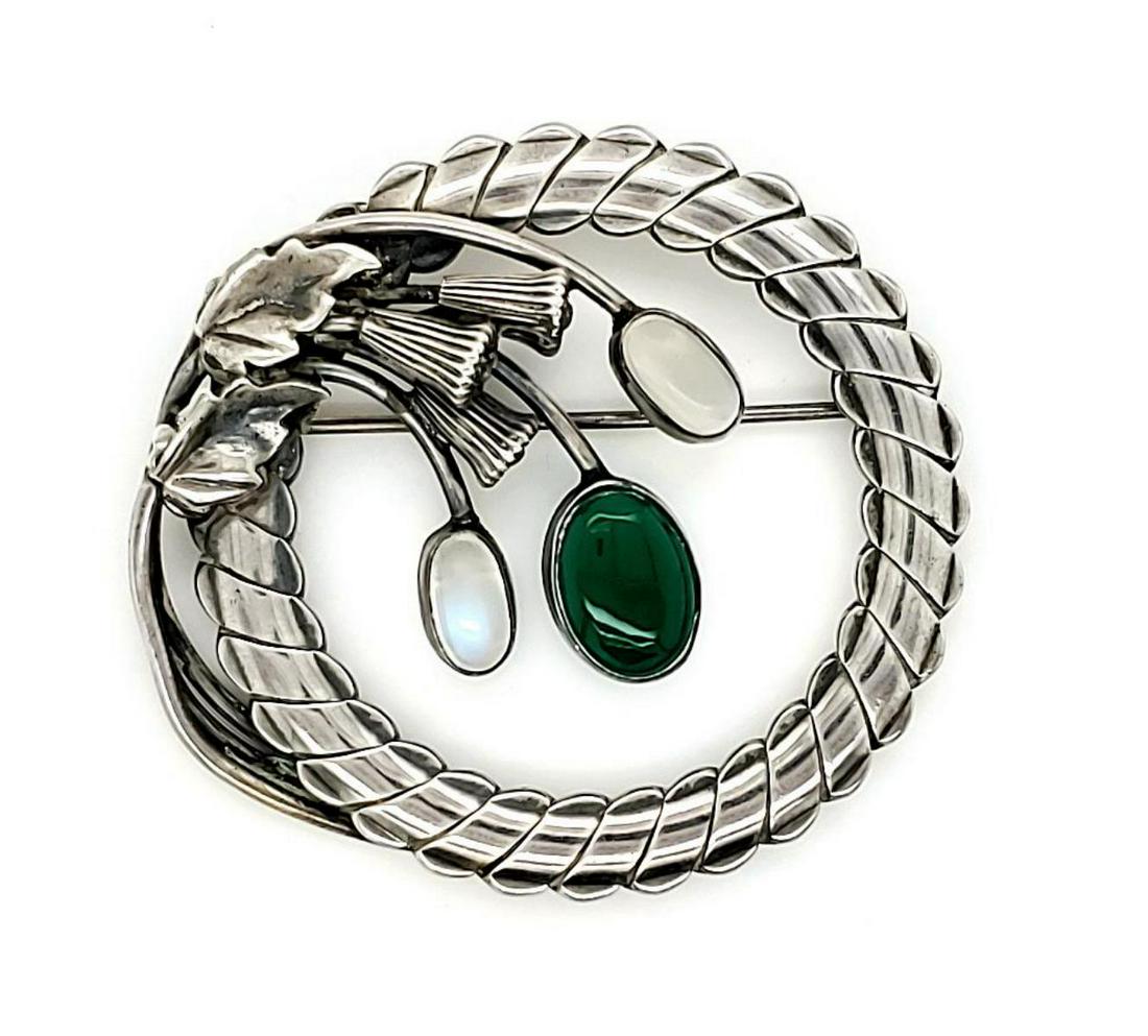 Sterling silver floral circle brooch: Ladies sterling silver brooch featuring a floral circle design and two oval cabochon cut moonstones weighing approx. 1.72ct. displaying adularescence, and one bezel set oval cabochon cut chrysoprase w