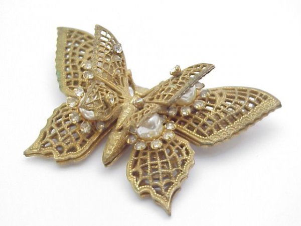 Miriam Haskell brooch: Lady's goldtone Miriam Haskell butterfly brooch containing 2 layer wings with moveable pearl and foil back rhinestones mounted between the wings.