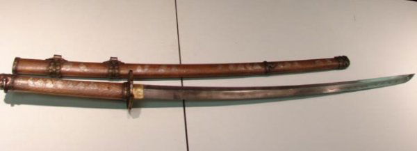 Japanese Sword Brass Saya Katana: Ancient signed brass Saya katana sword; not sure of age; cherry blossom tsuba; distinct homan on blade; beautiful art work on saya; blade 28; handle 15"; overall 45"; signature on tang. Prof. shipping