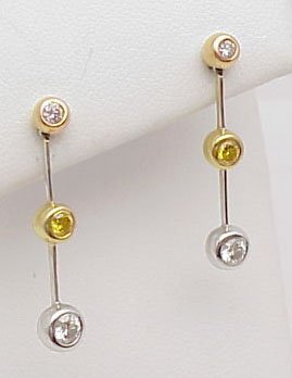 18k 3 tone diamond dangle earrings: Lady's 18k 3 tone diamond earrings weighing 4 grams. Earrings contain bezel set fancy intense yellow and white diamonds mounted on a white gold bar.
