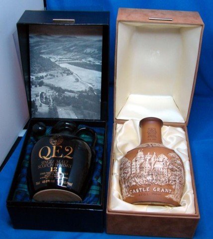 2 decanters: QE2 Scotch & Royal Doulton w/boxes: Lot of 2 decanters in original boxes, QE2 decanter in plaid lined box with a message to QE2 passengers, and a Castle Grant decanter designed by Royal Doulton. No chips or cracks (& no scotch either!)