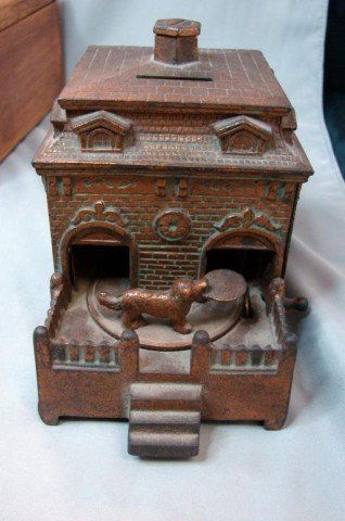 Antique Metal Bank Building circa 1920's: Metal bank of a building with a dog out front who carries in your money, handle on the side does work. 4 3/4" deep x 4" high x 3 1/4" wide, dated from the 1920's-1930's.