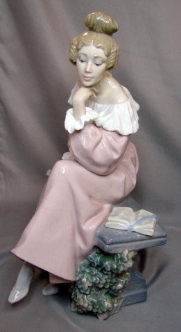 Lladro Renaissance Woman Sitting on Bench: Beautiful rare retired Lladro figurine of a woman wearing a pink long sleeve gown with ruffles at her off the shoulder neckline and cuffs and high top button boots sitting on a stone bench next to a b