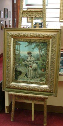 Antique Ornate Frames, one on an Easel: Two antique ornate wooden frames, 18 1/2" x 21 " and a large frame sitting on a matching easel, 29" x 32 3/4", with a picture, which looks hand colored.